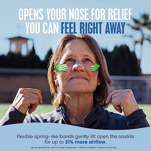 Person using nasal strips for congestion relief outdoors.